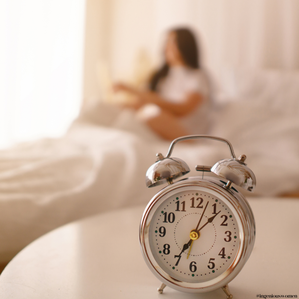 Empowered women getting out of bed for her morning routine in the background of a silver alarm clock